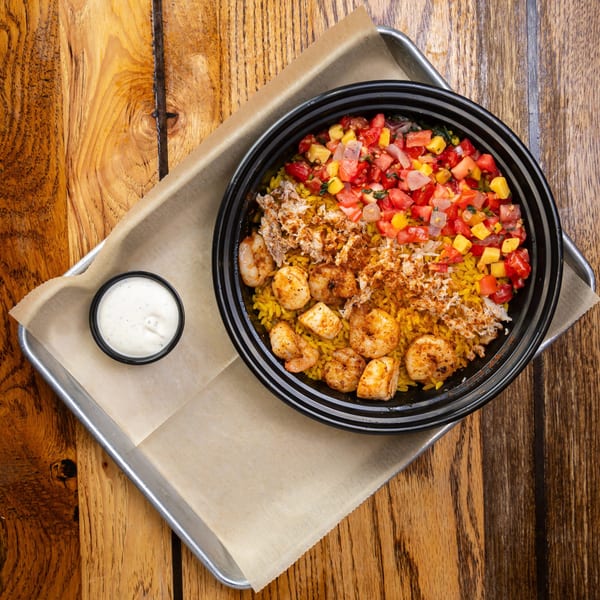 Charm City Seafood's shrimp and crab rice bowl with salsa and a side of sauce.